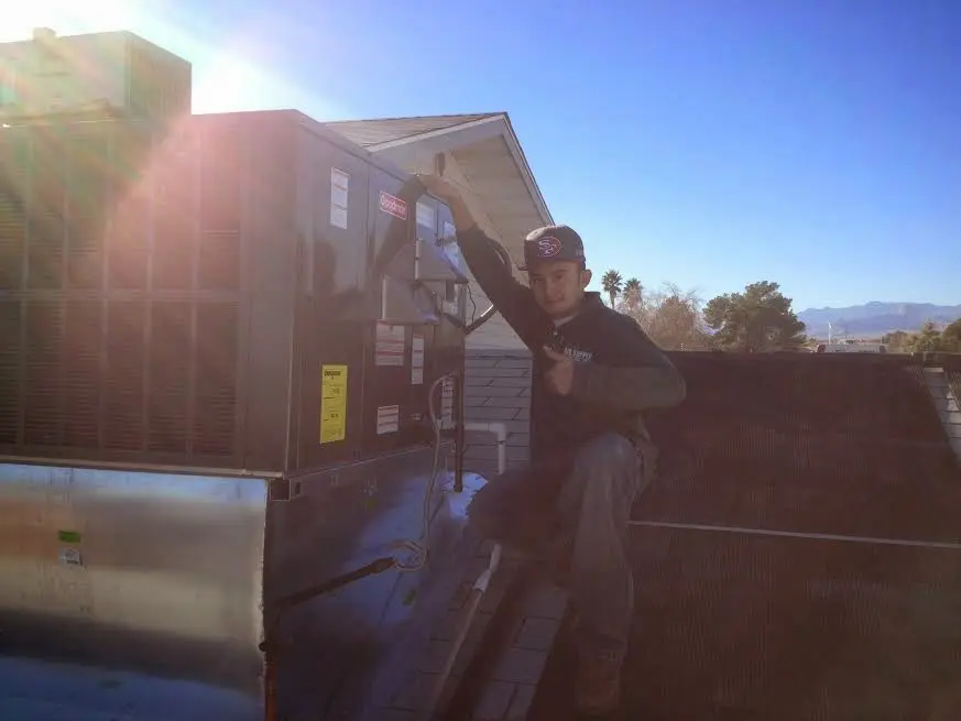 HVAC technician performing HVAC Inspection on a rooftop unit in Bolingbrook